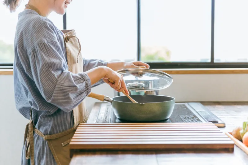 キッチンで調理するエプロン姿の女性